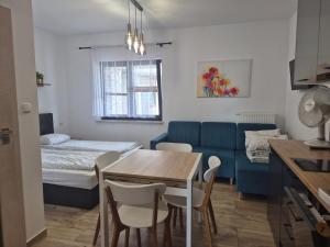 a small apartment with a blue couch and a table and chairs at Rajska Zatoka Jantar in Jantar +13 photos