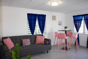 a living room with a couch and a table with pink stools at Armonia Rosada in Cabo Rojo