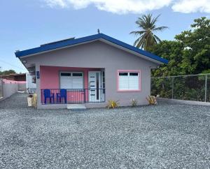a small pink house on a gravel driveway at Armonia Rosada in Cabo Rojo