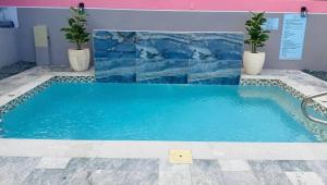 a swimming pool in a building with a blue wall at Armonia Rosada in Cabo Rojo