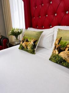 a bed with two pillows with dogs on it at Wampex Guesthouse in Potchefstroom