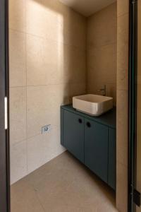 a bathroom with a sink and a blue cabinet at Persolis luxury sun residence in Kojsko +20 photos