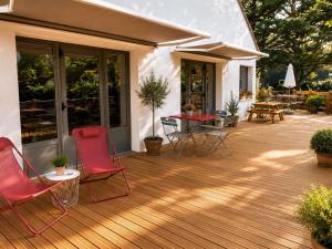 a wooden deck with chairs and a table on it at Greet hôtel Saint-Nazaire-Trignac, Nouvelle marque du groupe Accor in Saint-Nazaire +56 photos