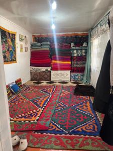 a room with a bunch of colorful carpets on the wall at Ademi Art in Kyzart