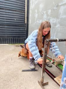 a woman bending over with a dog next to at Ademi Art in Kyzart