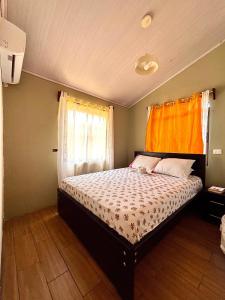 a bedroom with a bed with an orange curtain at Casa Malu in Morote