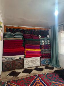 a room with a pile of colorful blankets and throws at Ademi Art in Kyzart +21 photos