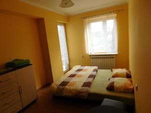 a bedroom with a bed and a dresser and two windows at Pokoje Gościnne Dastin in Ustroń