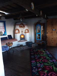 a living room with a fireplace and a rug at Maramureș Nook in Comarnic