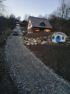 a house with a car parked on the side of a gravel road at Maramureș Nook in Comarnic