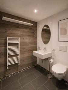 a bathroom with a white toilet and a sink at Art Residence, Beat Schild in Brienz +10 photos