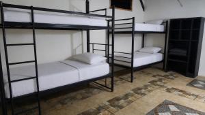 a room with three bunk beds in a room at My Backpacker House in Gili Trawangan