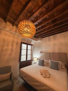 a bedroom with a large bed and a chandelier at 4U Hostel in Granada +68 photos