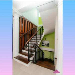 a spiral staircase in a house with green walls at Prabhaz grand villa in Hatton +1 photo