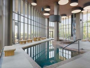 a pool in the lobby of a building with windows at Mercure Oradea in Oradea