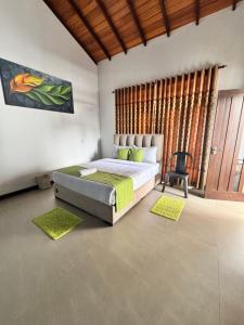 a bedroom with a bed with green sheets and a chair at Prabhaz grand villa in Hatton