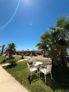 a table and chairs on the grass near a beach at Todo Luxury Suites in Durrës +31 photos