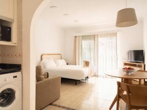 a bedroom with a bed and a table and a kitchen at Ona Village Cala d'Or in Cala d´Or +33 photos