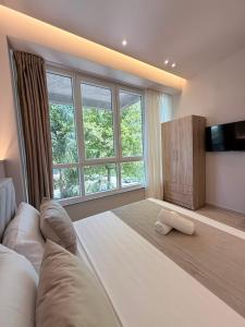 a large bedroom with a large bed and a large window at Todo Luxury Suites in Durrës