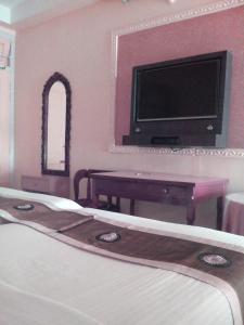 ein Hotelzimmer mit einem Bett und einem TV in der Unterkunft Hotel Mahalaxmi Indo Myanmar in Guwahati