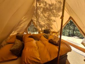 a bed in a tent with pillows on it at Halden Glamping in Halden