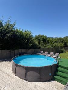 a large swimming pool with chairs around it at Садиба Трембіта з сауною та чаном in Rakhiv