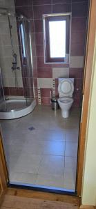 a bathroom with a toilet and a tub and a window at Къща за гости ЧЕРИ in Tryavna +14 photos