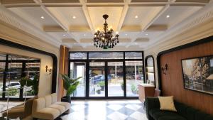a lobby with a chandelier and chairs in a building at Green Plaza Inn in Alexandria