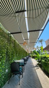 a row of tables and chairs under a canopy at Green Plaza Inn in Alexandria