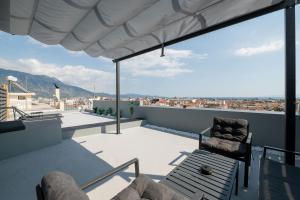 a balcony with a chair and a view of a city at Luxury Black and White Interior Apartments & Rooftop Terrace in Kalamata