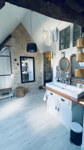 a bathroom with a sink and a mirror at La Closerie Teranga in Bayeux