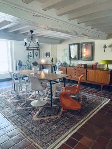a dining room with a table and chairs on a rug at La Closerie Teranga in Bayeux