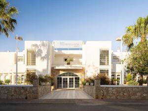a white building with a gate and palm trees at Ona Village Cala d'Or in Cala d´Or