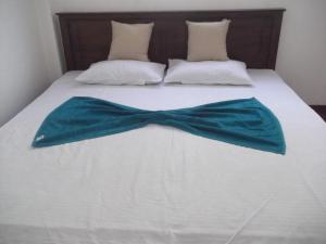 a bed with a blue bow tie on it at Wishwa Villa in Weligama
