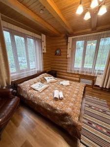 a bedroom with a large bed with slippers on it at Дикий Кіт in Vorokhta