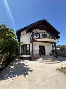 a house with a balcony on top of it at Vila MaeStar in Curtea de Argeş