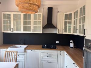 a kitchen with white cabinets and a black wall at Villa Mario in Senigallia +10 photos