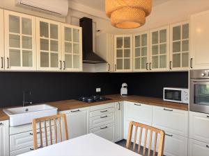 a kitchen with white cabinets and a table and chairs at Villa Mario in Senigallia