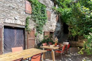 a patio with a table and chairs in front of a building at Chambres Et Table D'hôtes De Vernet in Saint-Germain-de-Calberte
