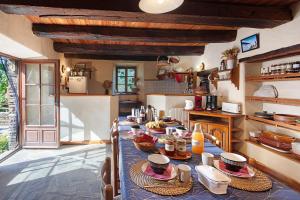 a kitchen with a long table with food on it at Chambres Et Table D'hôtes De Vernet in Saint-Germain-de-Calberte