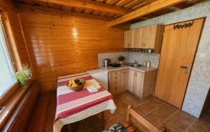 a small kitchen with a table with a bowl of fruit on it at Chata Huta in Muránska Huta