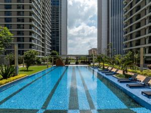 a swimming pool with lounge chairs and buildings at Pan Pacific Suites Nairobi in Nairobi