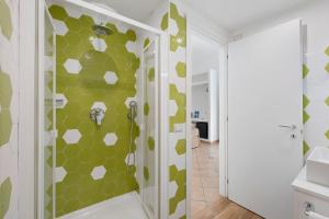 a bathroom with a shower with green and white tiles at Sorrentina Guest House in Sorrento +105 photos