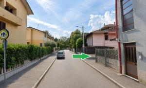 a car driving down a street with a green arrow at Corte del Gallo in Legnano