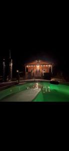 a house lit up at night with a swimming pool at Brynmeini Lake Lodge in Glogue Station