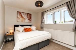a bedroom with a bed and two windows at Beautiful Abode in The Bath Cotswolds in Frome