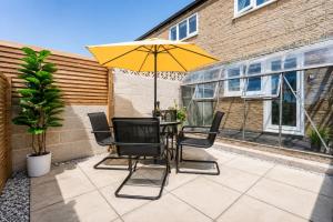 a table and chairs with an umbrella on a patio at Beautiful Abode in The Bath Cotswolds in Frome