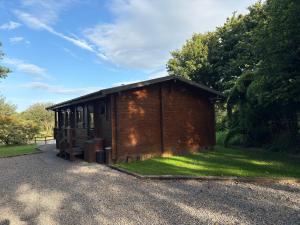 a small brick building on the side of a road at Brynmeini Lake Lodge in Glogue Station