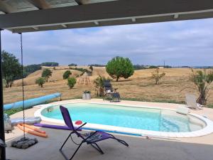 a swimming pool with chairs around it in a field at Chambre chez l'habitant "lou Castanier" in Cayrols