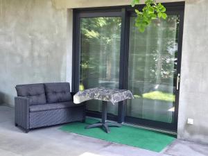 a chair and a table on a porch with a chair and a glass door at Via Mare in Jantar